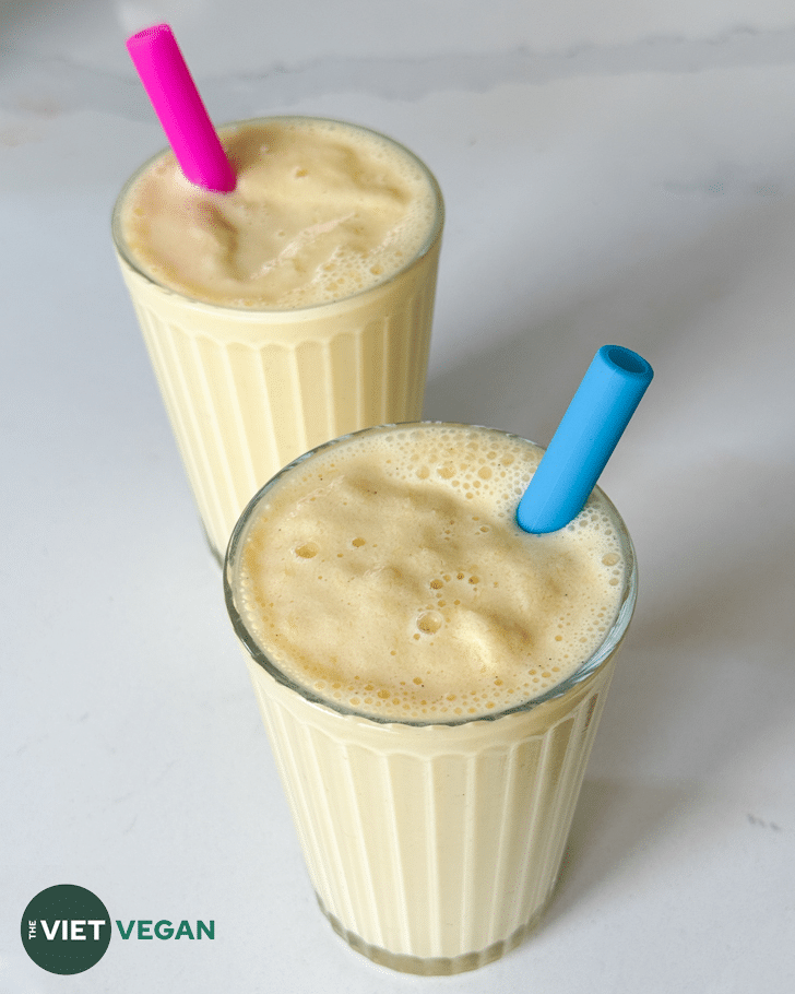 vegan orange cream milkshake in two glasses with colourful silicone straws